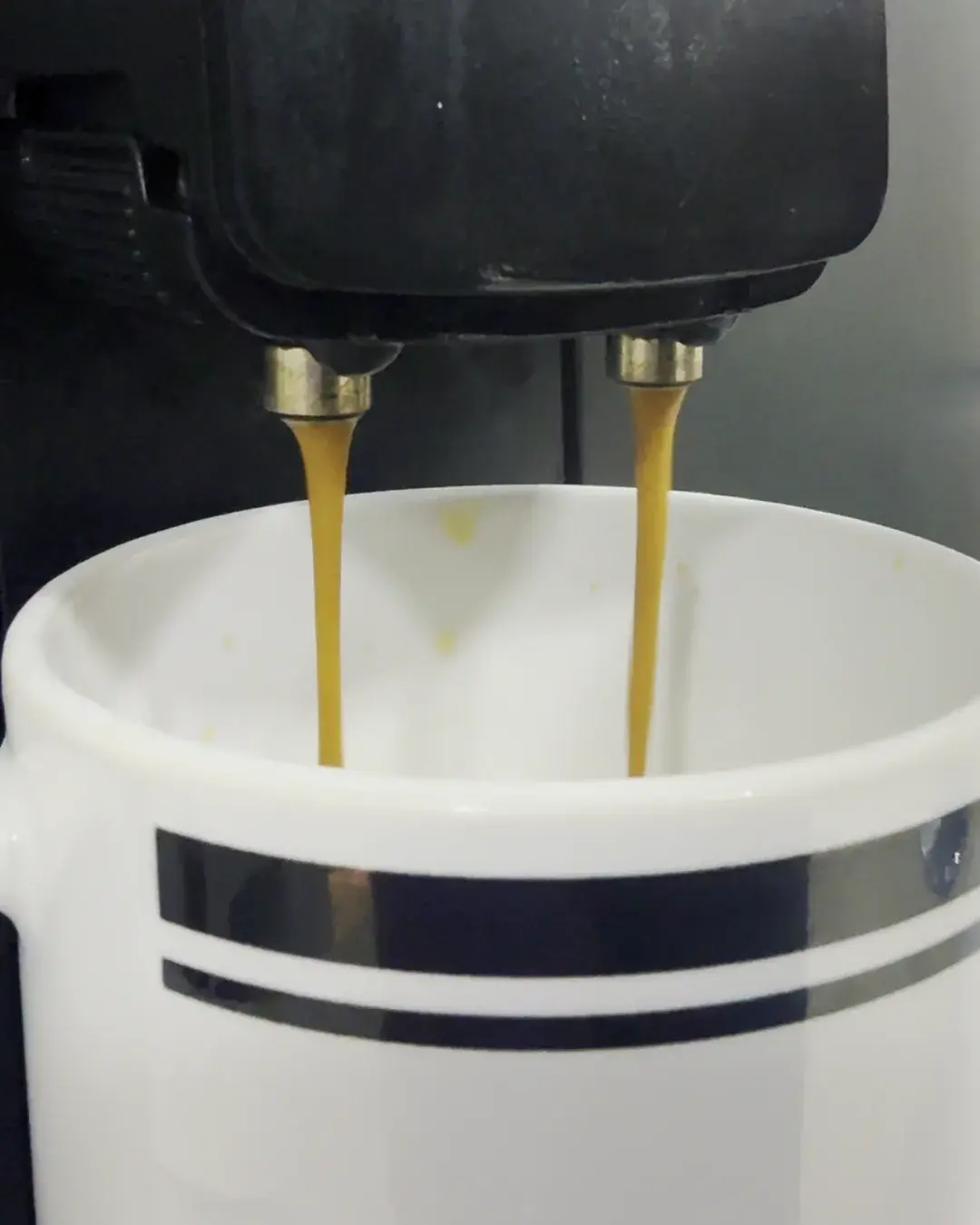 Dois jatos de café saindo da máquina diretamente na xícara